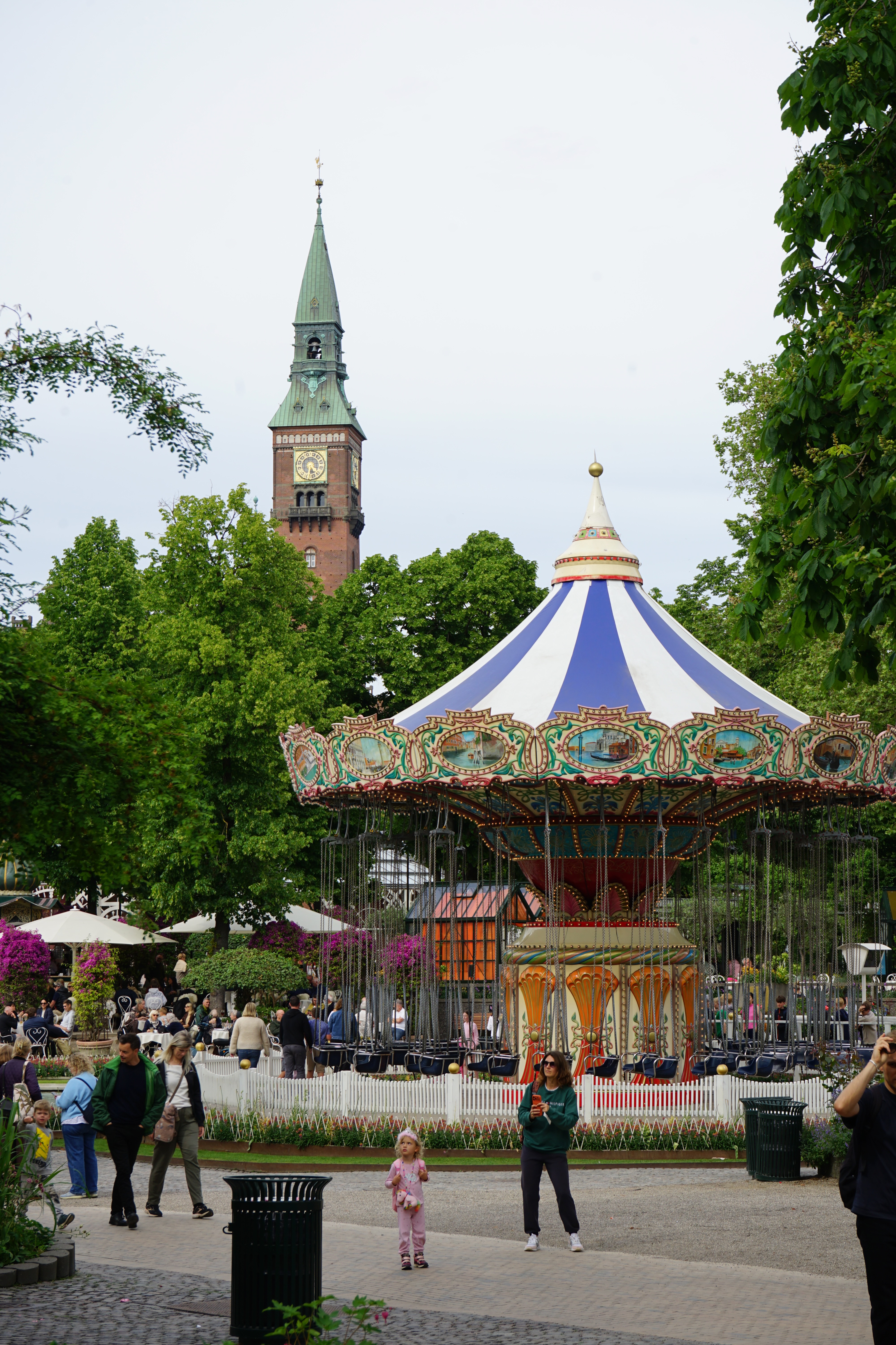 Tivoli Gardens carousel with Copenhagen City Hall tower behind it